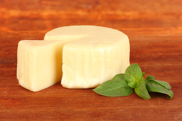 Cheese mozzarella and basil on wooden background