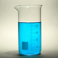 test-tube with blue liquid on grey background