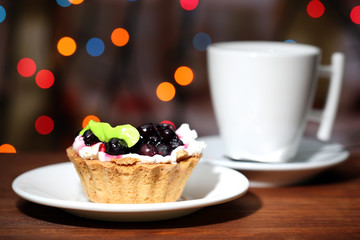 Tasty blackberry cake and cup of beverage,