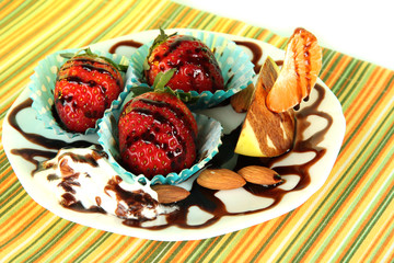 Fruit in chocolate on plate on tablecloth close-up