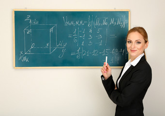 Portrait of teacher woman near the chalkboard in classroom