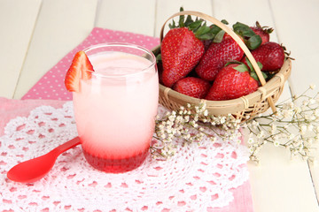 Delicious strawberry yogurt in glass on wooden table close-up