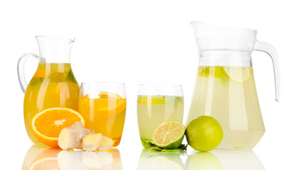 Orange and lemon lemonade in pitchers and glasses isolated