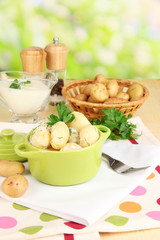 Tender young potatoes with sour cream and herbs in pan