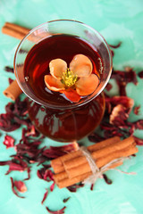Herbal tea in glass cup, on color wooden background