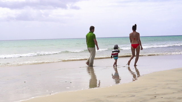 Happy family walking on the beach, super slow motion