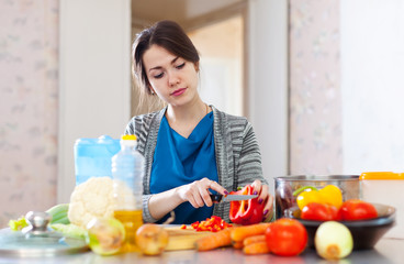  woman cuts red pepper