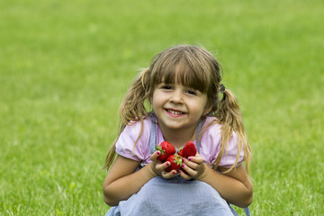 Fototapeta premium girl holds strawberries