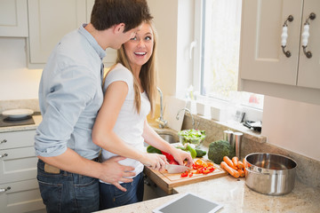 Man laughing with woman preparing vegetables