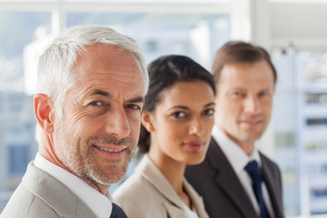 Smiling business people looking in the same way