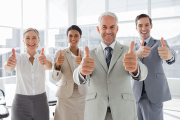 Business people giving thumbs up