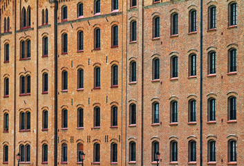 Facade of an old brick building with many windows.