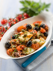 squid with tomatoes olives and capers, selective focus