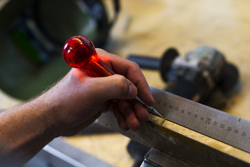 measuring metal object with ruler