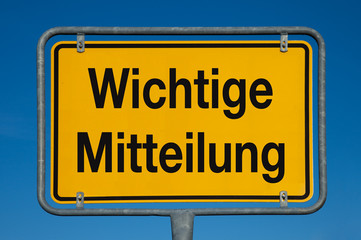 Ortsschild mit blauem Himmel WICHTIGE MITTEILUNG