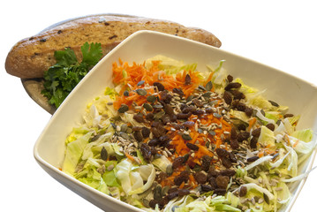 Salad dish with cabbage,carrots,seeds,raisins,homemade bread