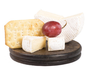 cheeses, cracker on the wooden board isolated on white