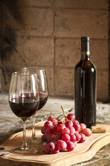 Copa de vino tinto y botella de vino, uvas.