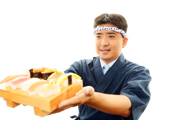 寿司を差し出す笑顔の寿司職人
