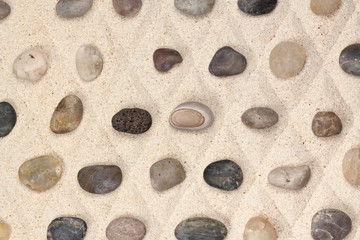 Fototapeta na wymiar galets sur sable quadrillé