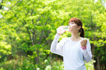 Fototapeta premium Beautiful young woman drinking water at workout