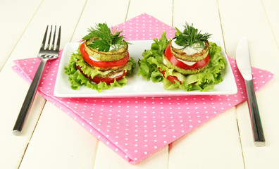 Tasty roasted marrow and tomato slices with salad leaves,