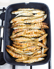 Fried small smelt fish on a barbecue grill  hotplate
