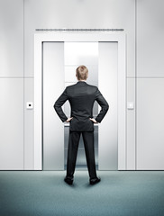 Fototapeta premium man standing in front of elevator's door