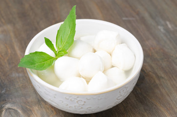 fresh mozzarella and basil in a bowl, close-up horizontal