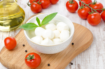 fresh mozzarella in a bowl, cherry tomatoes and olive oil