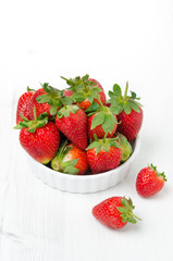 Fresh ripe strawberries in a bowl, vertical