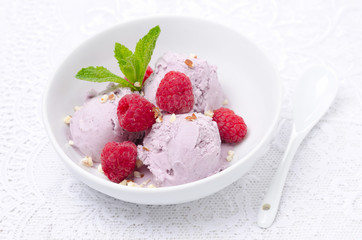 ice cream with raspberries in white bowl