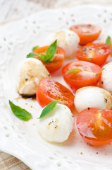 salad with mini mozzarella, cherry tomatoes, fresh basil closeup