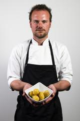 young chef holding bowl with potatos