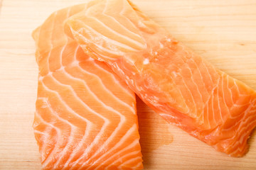Two Atlantic Salmon Fillets on a Wood Cutting Board