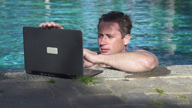 Swimmer with laptop in the pool, super slow motion