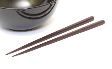 Dark wooden chopsticks and ceramic bowl