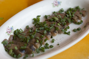 Herring fillet with green onion on a plate