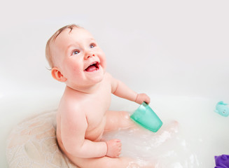 Cute happy baby laughing in a bathroom