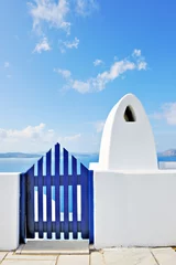 Photo sur Plexiglas Santorin Porte et cheminée grecques traditionnelles donnant sur la caldeira à Oi