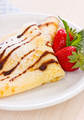 Crepes with chocolate syrup and strawberry