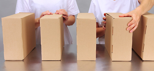 Workers working with boxes at conveyor belt, on grey background