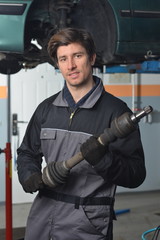 Fototapeta na wymiar Mechanic holding car part and smiling