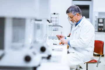 Foto op Plexiglas Senior male researcher carrying out scientific research in a lab © lightpoet