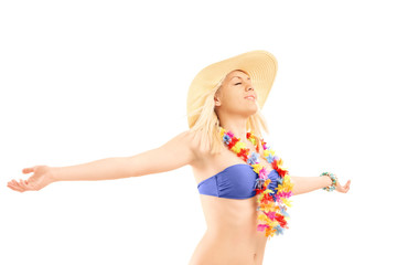 Relaxed blond female in bikini spreading her arms