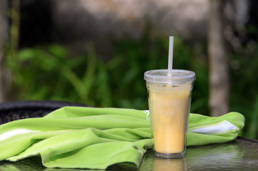 Mango shake outdoor with a green sport shirt on the table
