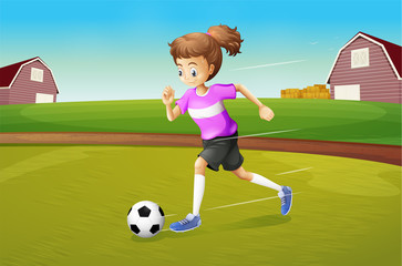 Fototapeta premium A girl playing football at the farm