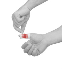 Hand putting medical bandage on bloody thumb wound
