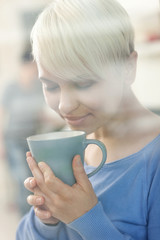 Attractive woman enjoying her coffee behind a window