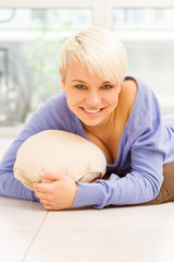 Smiling woman with short hairs laying on a pilow